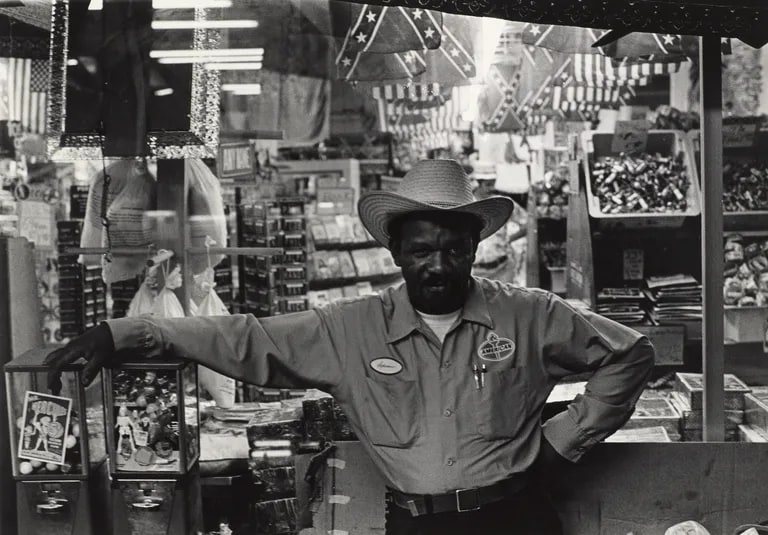 Man in a cowboy hat in front of a store window