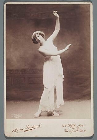 Portrait of dancer in stage dress (entire figure, at studio)