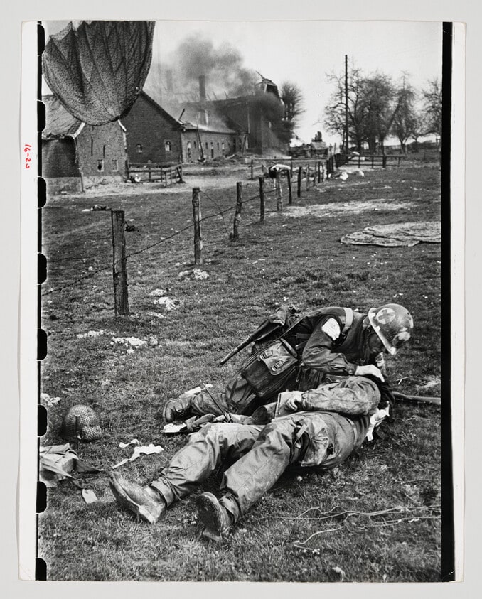 Paratrooper medic of the U.S. 17th Airborne Division treats a wounded paratrooper during the first moments of the invasion of Germany, September 25, 1945