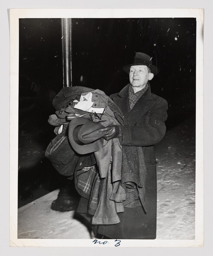 Untitled (Man walking with armful of clothes)