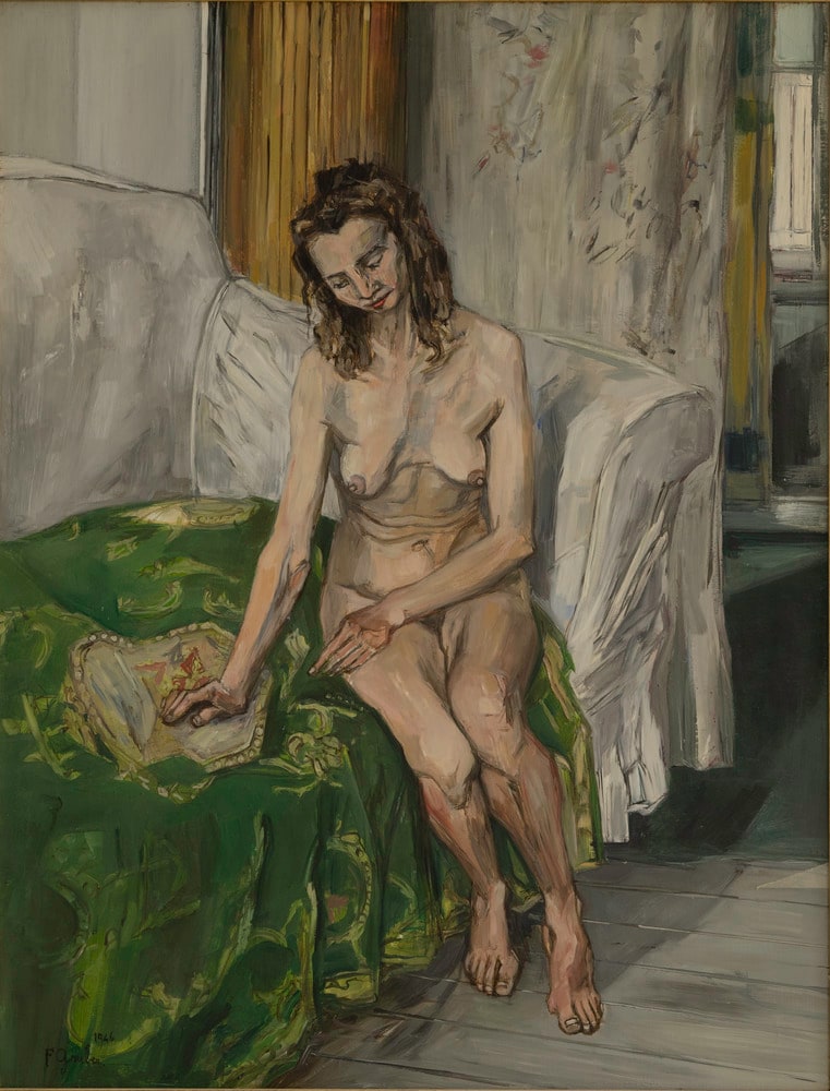 Femme assise au canapé vert