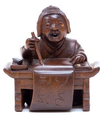 Netsuke of a child at writing desk