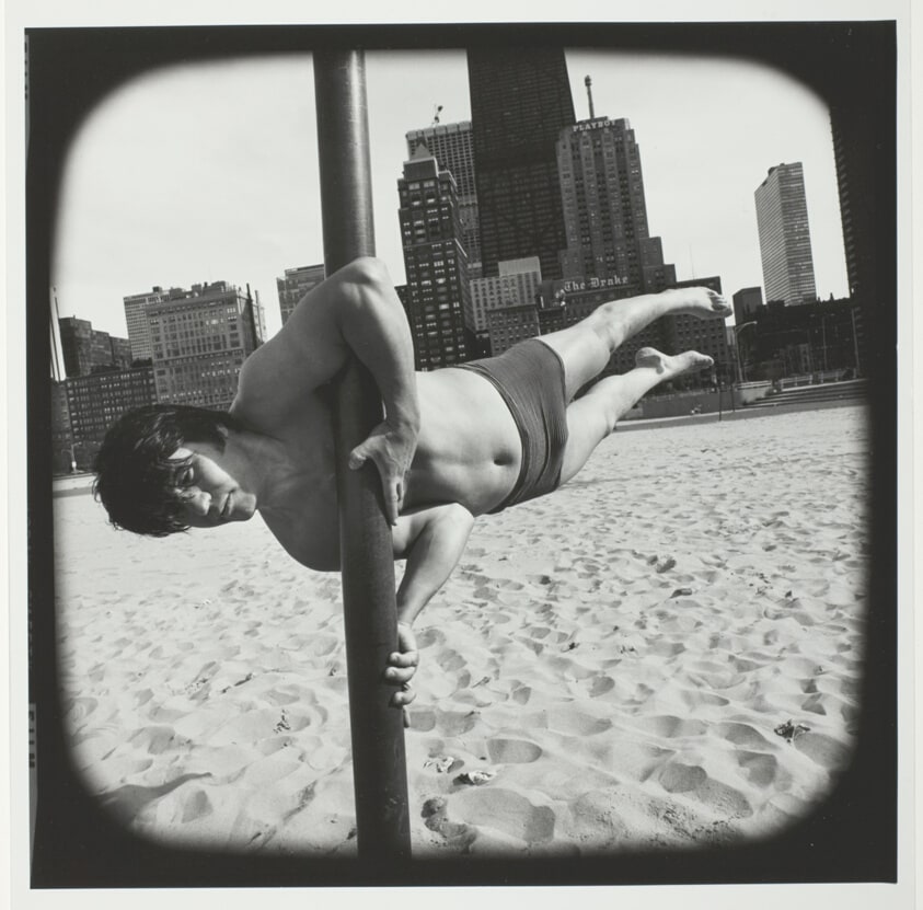 Untitled (Man in Bathing Suit Balancing Himself on Pole Vertical to the Sand), from the series "Beach"