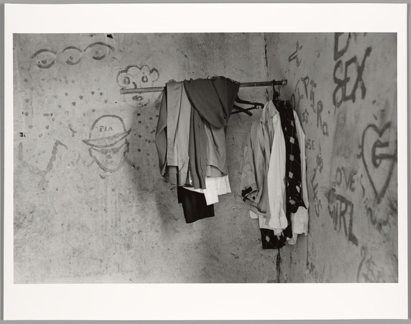 Mkansi household, bedroom with graffiti and the clothes of their late parents