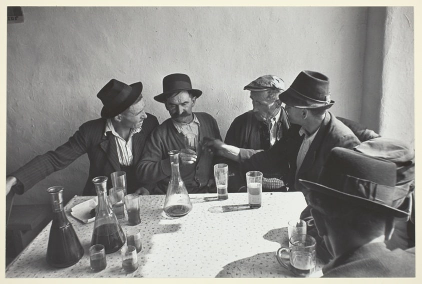 Men Seated Around a Table Drinking Wine