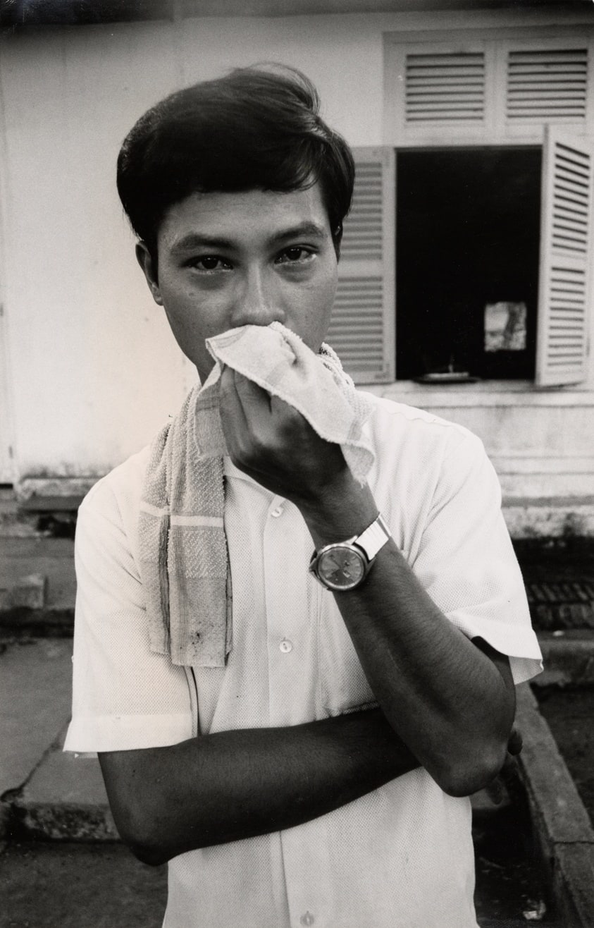Vietnam peace fact-finding mission: one of the peace marchers, a Vietnamese student, wipes teargas from his eyes after the peace march has been broken up by the Saigon police