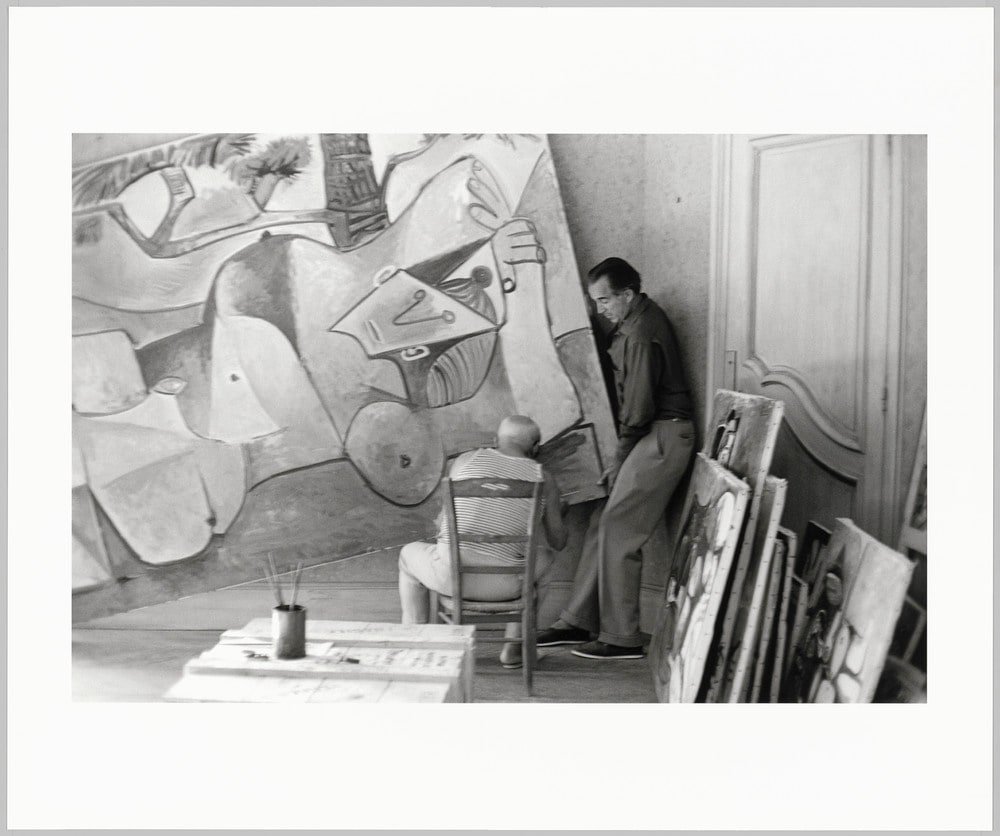 Pablo Picasso signant la toile "Femme nue sous un pin" le jour des signatures et David Douglas Duncan en train de soulever le coin de la peinture, dans l'atelier de La Californie, Cannes, en septembre 1960