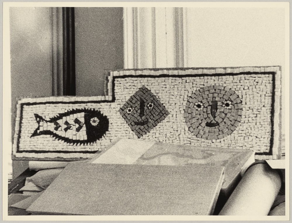 Premier essai de mosaïque en collaboration avec Hjalmar Boyesen au bout d'une table encombrée de livres, dans l'atelier de La Californie, Cannes, [fin 1956-1957]