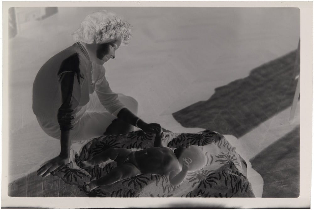 Catherine Hutin tenant la main de Bernard Picasso bébé allongé au sol à La Californie, Cannes [1959]