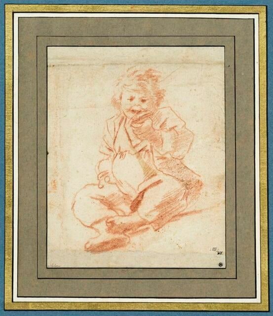 Un enfant assis, vu de face, en train de manger