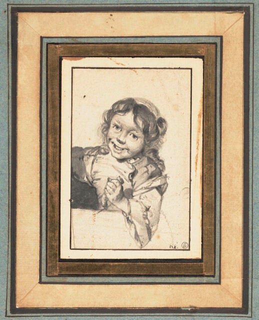 Petite fille aux cheveux bouclées, riant et tenant une saucisse