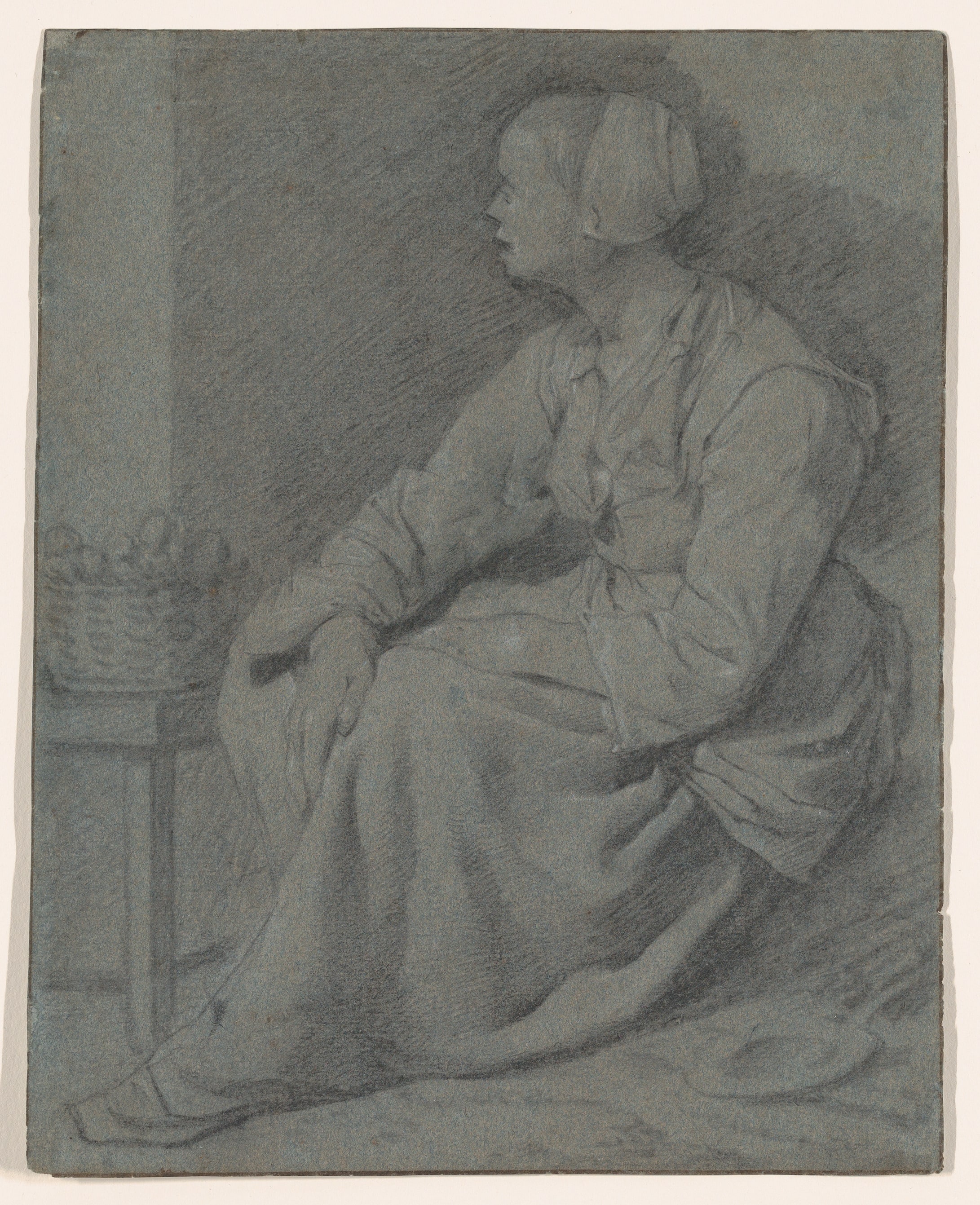 A Woman Seated Near a Basket on a Stool