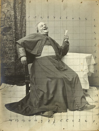 Homme vêtu d'un costume de cardinal, assis un verre à la main