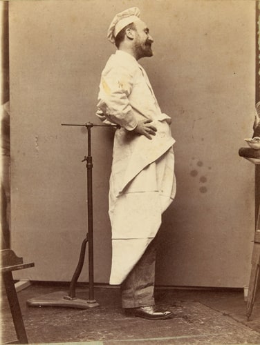 Homme debout, de profil, vêtu d'un costume de mitron