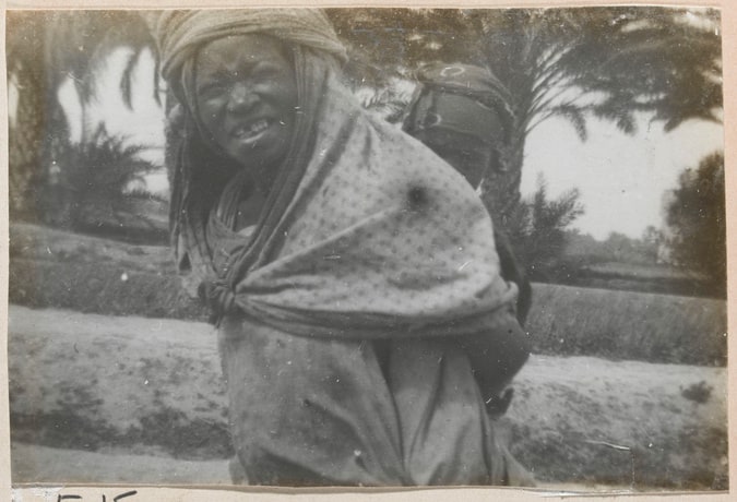 Femme portant un bébé sur le dos