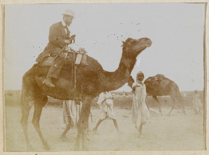 Homme assis sur un chameau