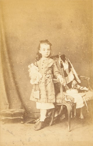 Laurence Alma-Tadema, romancière et poètesse, fille aînée du peintre, à l'âge de cinq ans, debout près d'un fauteuil