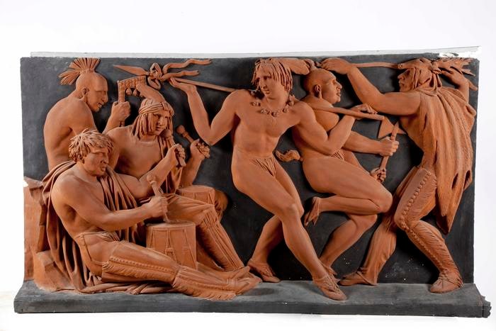 Bassorilievo raffigurante dei Nativi della Nazione Sauk-Fox e della Nazione Sioux del Mississippi, impegnati in una danza guerriera. L'opera è divisa in tre scene.